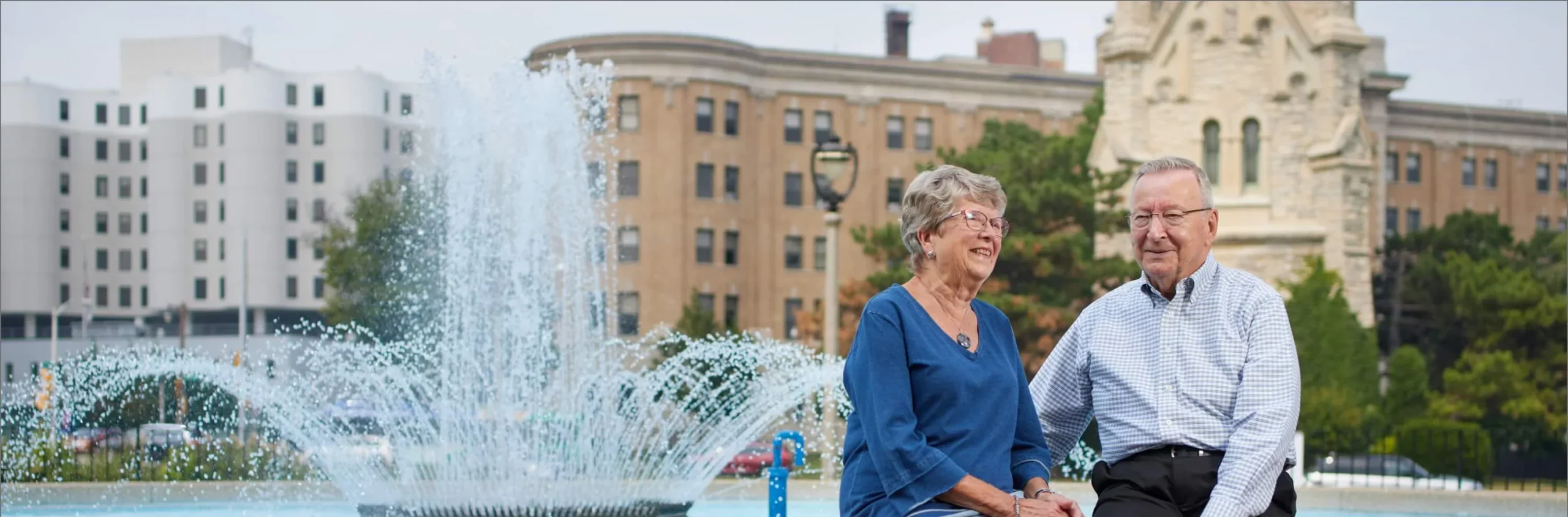 Two seniors enjoying a day by a fountain
